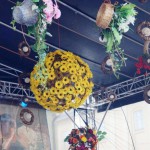 Kula ze słoneczników i bukiety zielne w koszykach wiklinowych zostały powieszone jako dekoracja nad sceną.