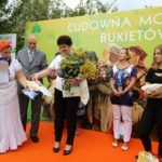 Prowadząca konkurs wręcza na scenie dyplom laureatce trzymającej bukiet zielny. Za nimi stoi poseł Bogusław Sonik, obok nich stoją dwie kobiety.