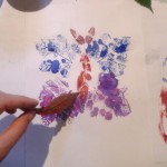 Malowanie obrazku motyla stworzonego przy pomocy liści odbitych farbą.