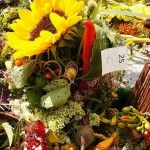 Zdjęcie zgłoszonego do konkursu bukietu zielnego zawierającego słonecznik, jarzębinę, żółte i różowe kwiaty oraz zioła. Bukiet ma przyczepiony numerek.